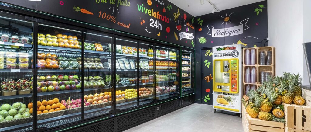 Interior de la tienda Vivelafruta en ÀnecBlau Castelldefels con lineales de fruta, verdura, zumos y productos frescos